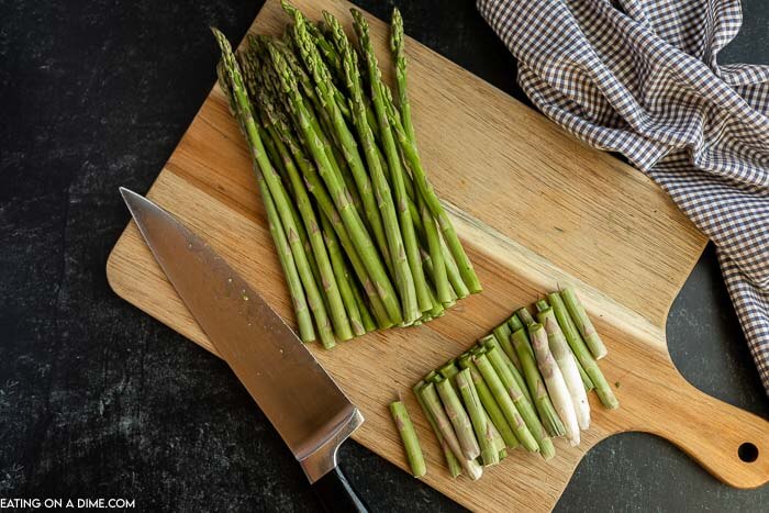 Cut asparagus on a cutting board with a knife