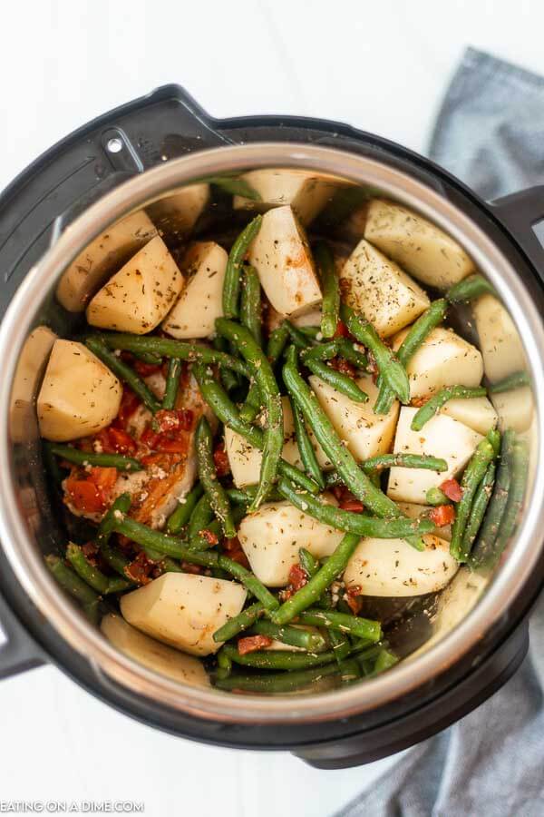 Pork chops, potatoes, and green beans with seasoning in the instant pot