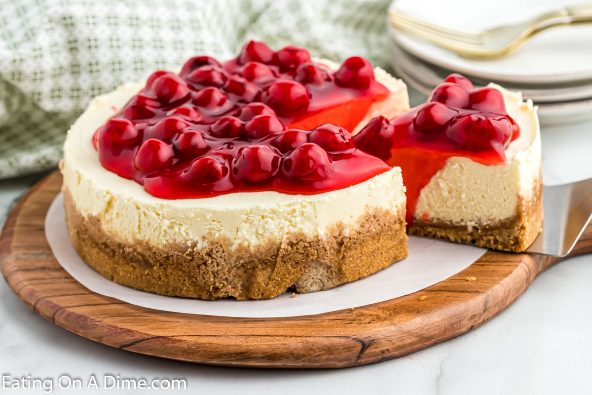 Instant Pot Cheesecake  topped with cherries being sliced. 
