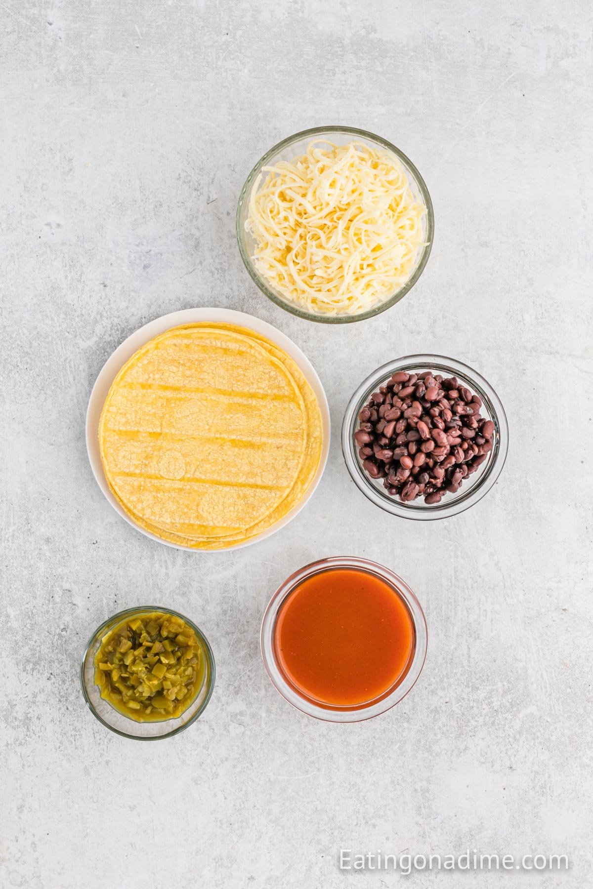 Ingredients for Bean and Cheese Enchiladas - Black beans, green chiles, red enchilada sauce, corn tortillas, monterey jack cheese, cilantro, green onions