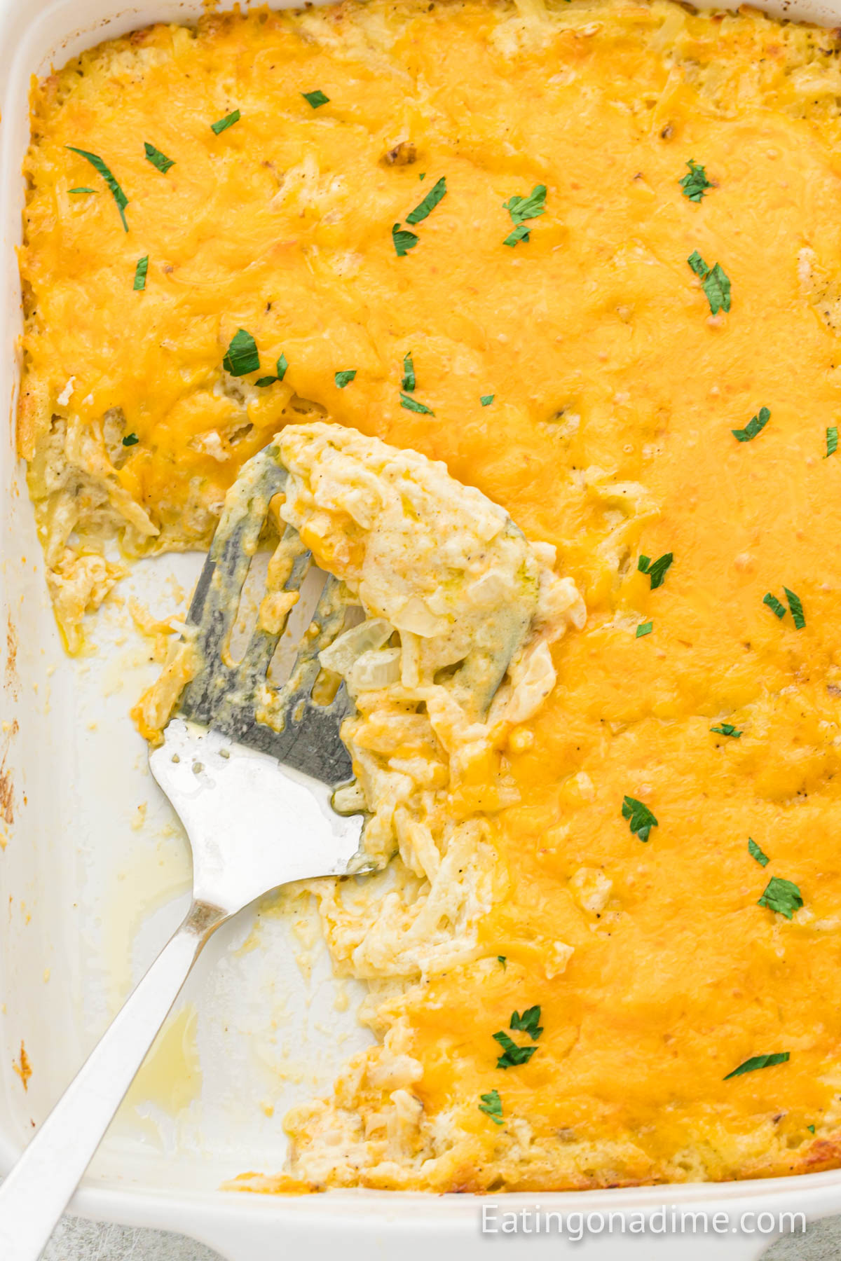 Cheese Hashbrown Casserole in a baking dish with a spatula