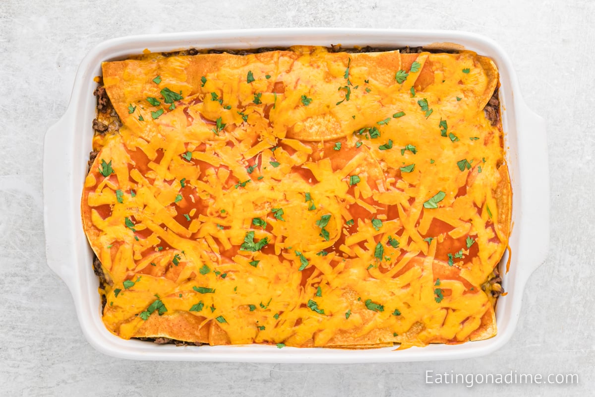 Close up image of beef enchilada casserole in a baking dish