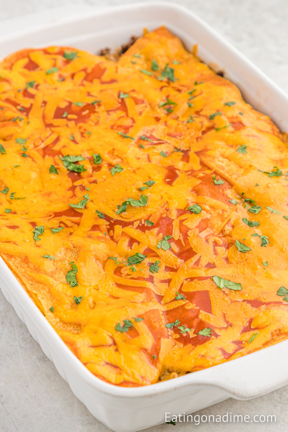 Close up image of beef enchilada casserole in a baking dish