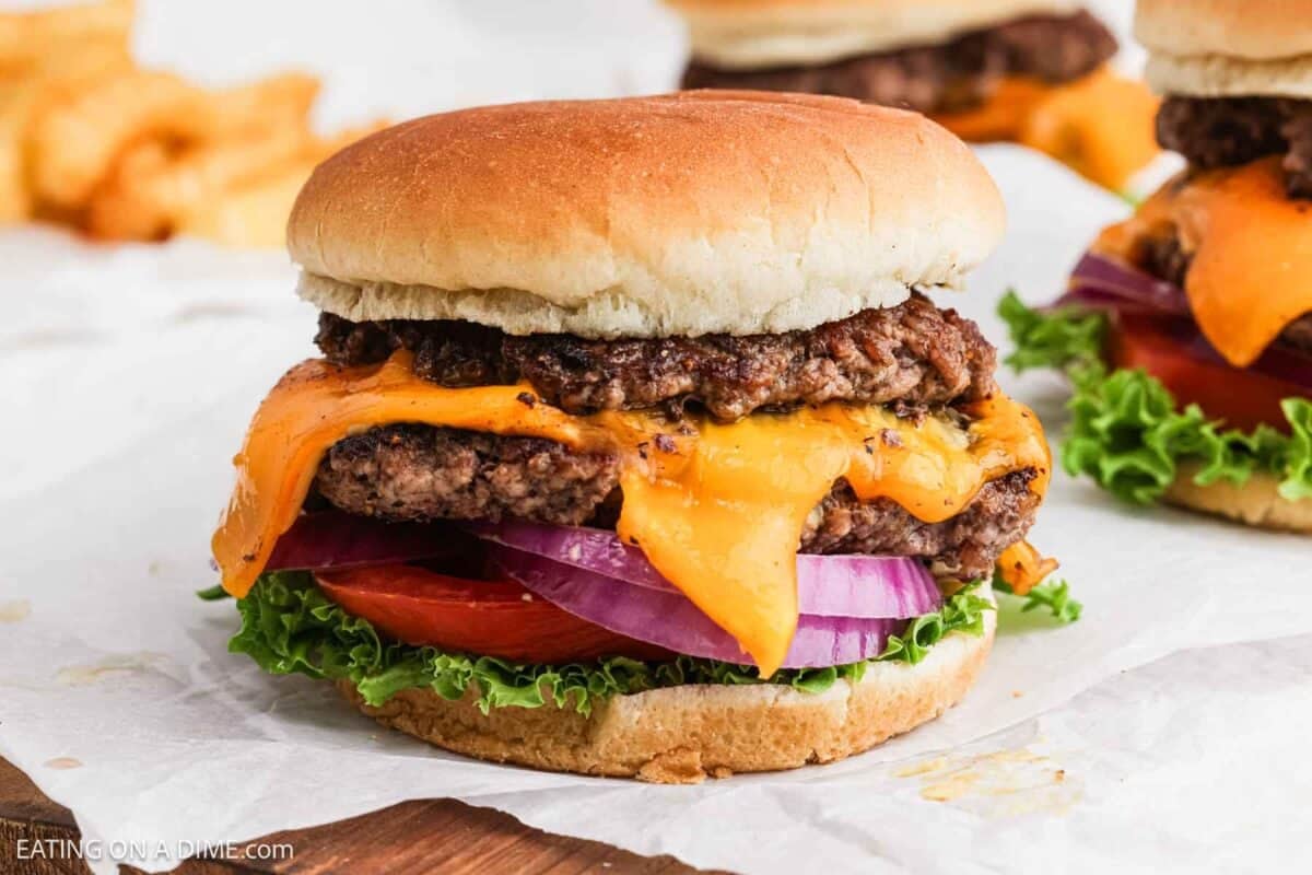 Smash burger topped with slice melted cheese, red onions, slice tomatoes and lettuce. 