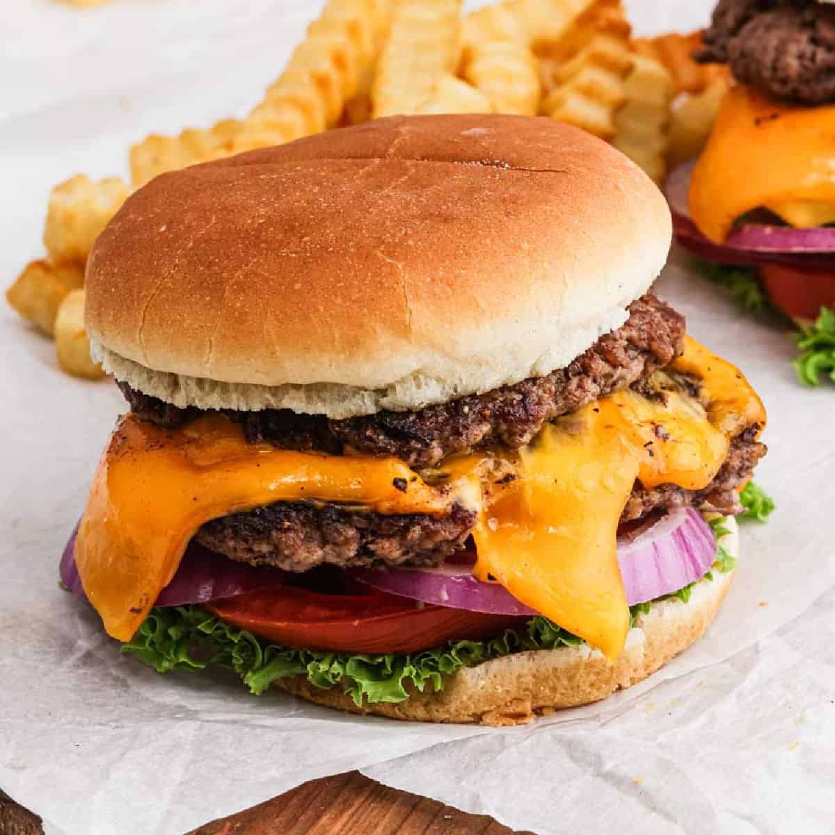 Smash Burger topped with melted cheese, red onions, tomato and lettuce.