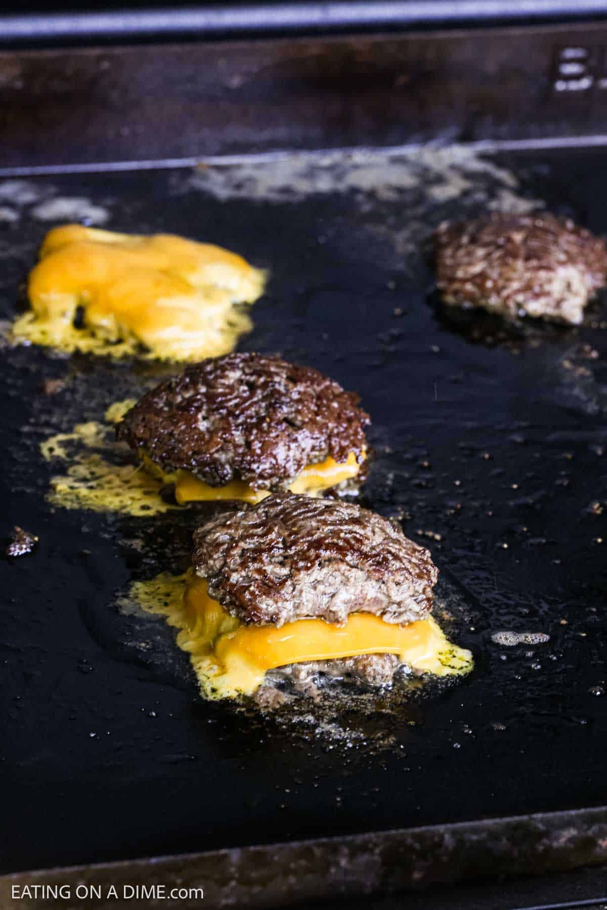 Cooked hamburger patties on the flat top griddle.