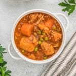 Hearty chicken and vegetable stew in a white bowl, perfect for budget-friendly meals.