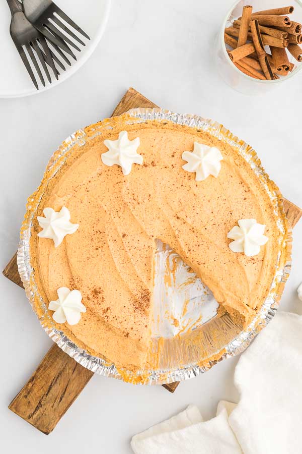 Whole no bake pumpkin pie with a slice missing