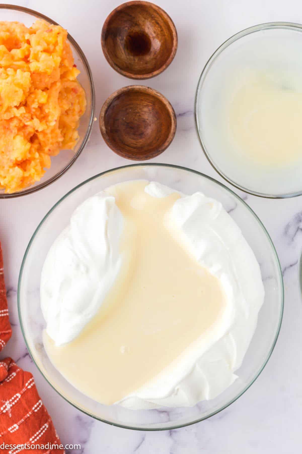 Whipping cream, vanilla, salt and sweetened condensed milk in a bowl.
