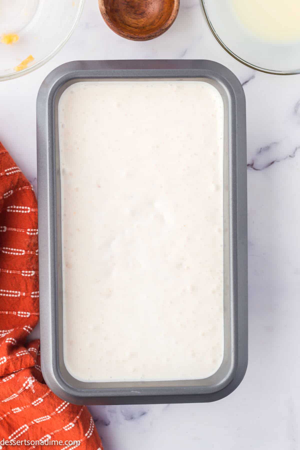 Ice cream mixture poured into a loaf pan to prepare for freezing.