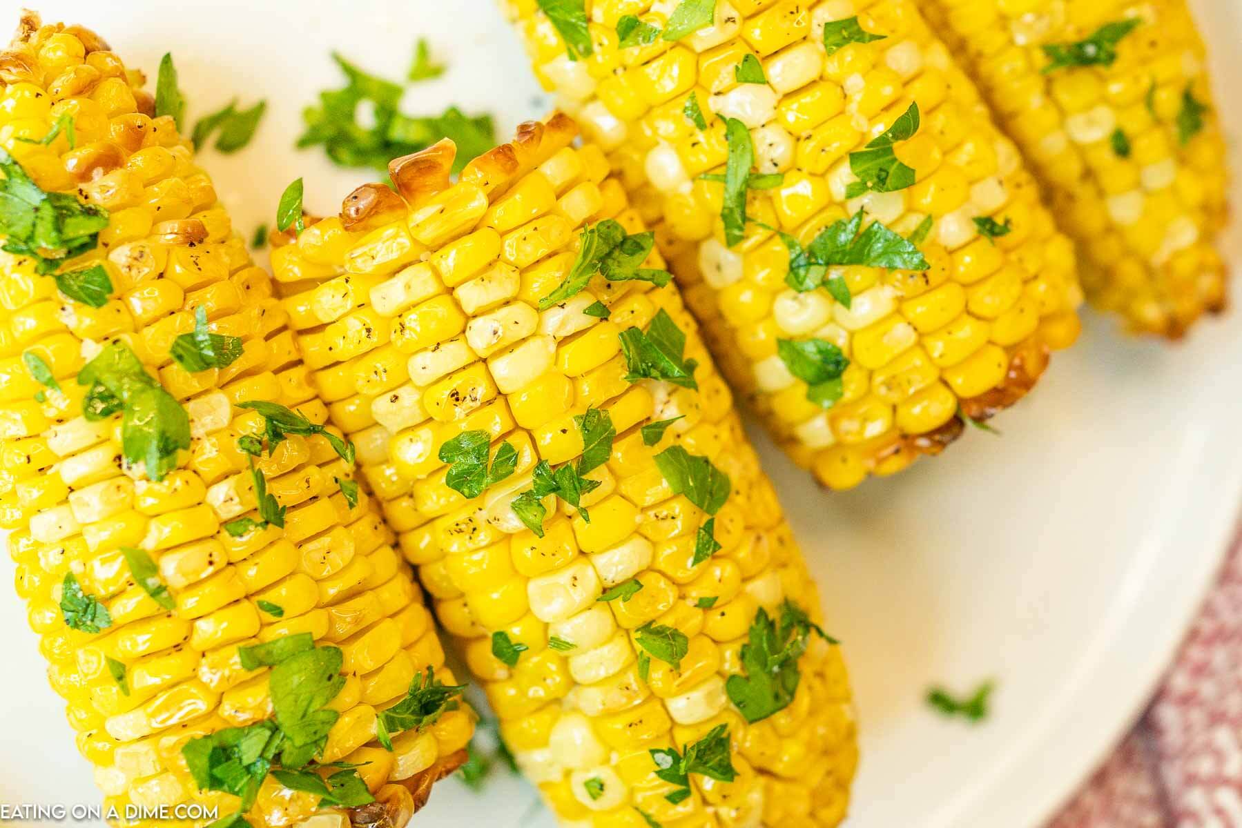 Air Fryer Corn on the Cob on a plate topped with cilantro