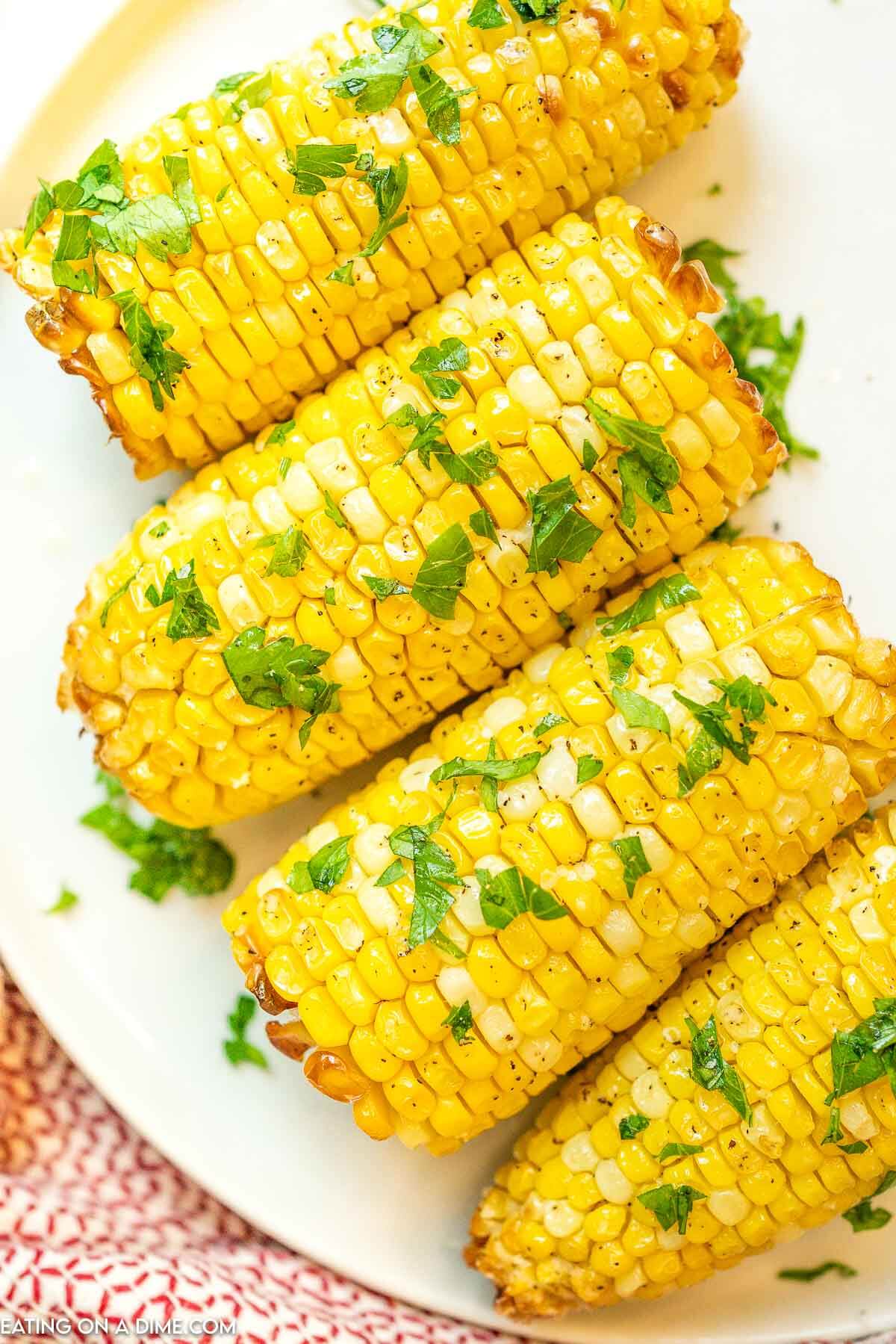 Air Fryer Corn on the Cob on a plate topped with cilantro