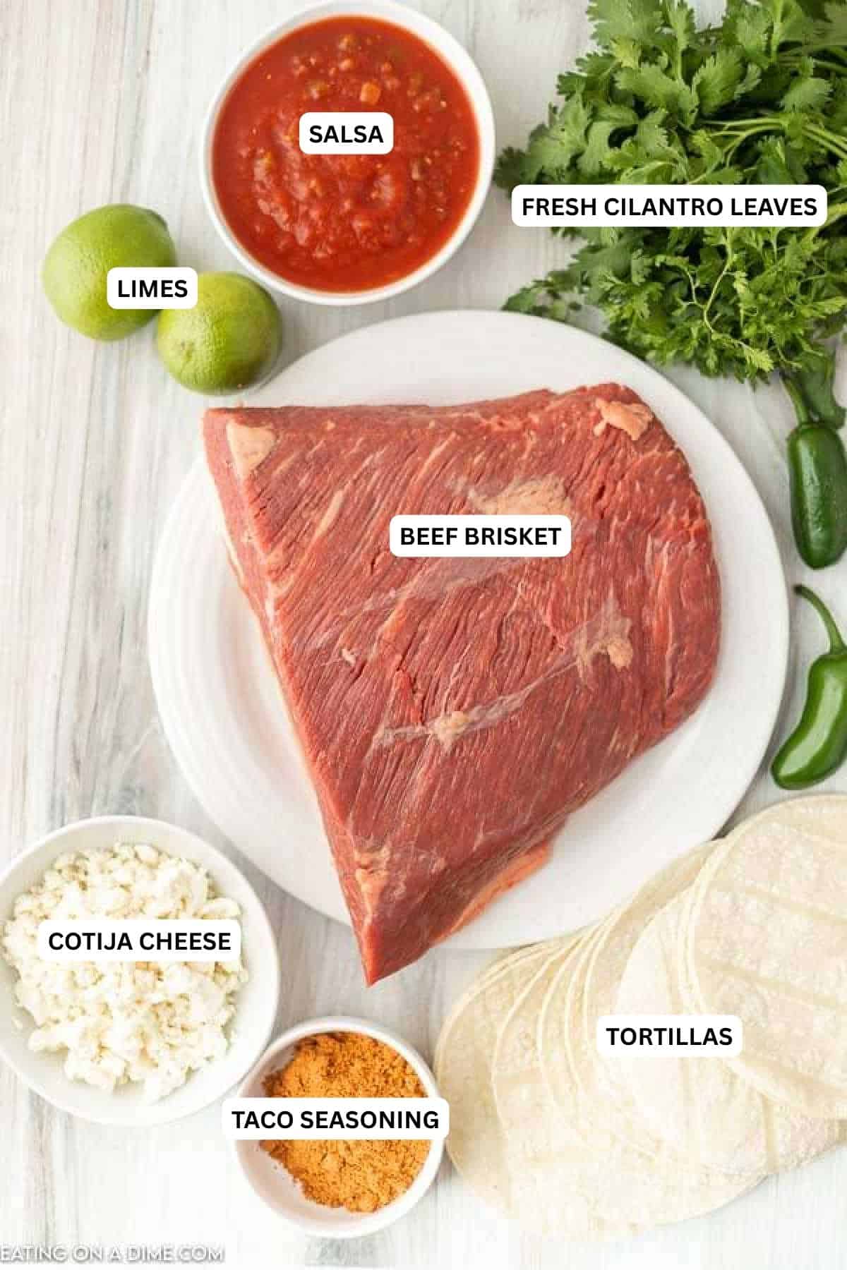 Ingredients for recipe: salsa, limes, cilantro, beef brisket, Cotija cheese, taco seasoning and tortillas.