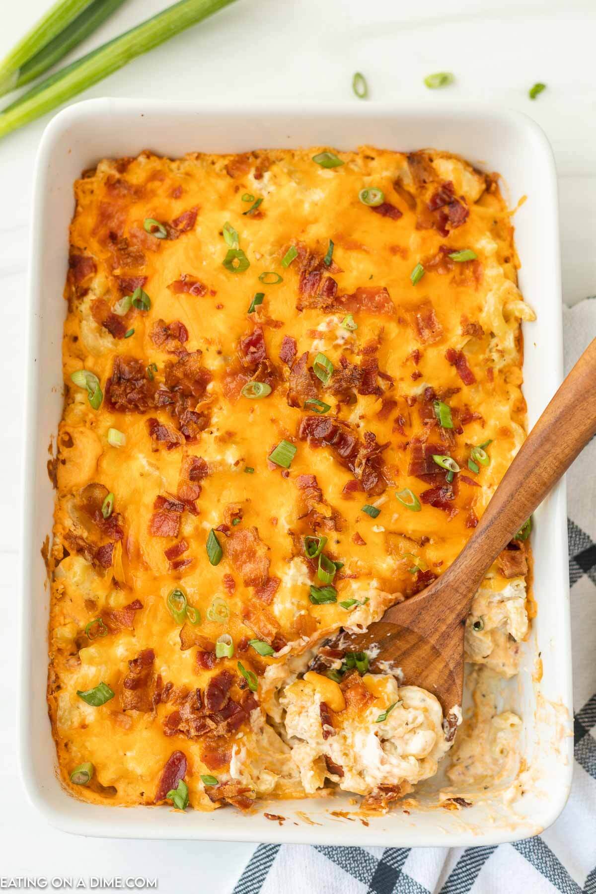 crack chicken casserole in a baking dish with a serving on a wooden spoon