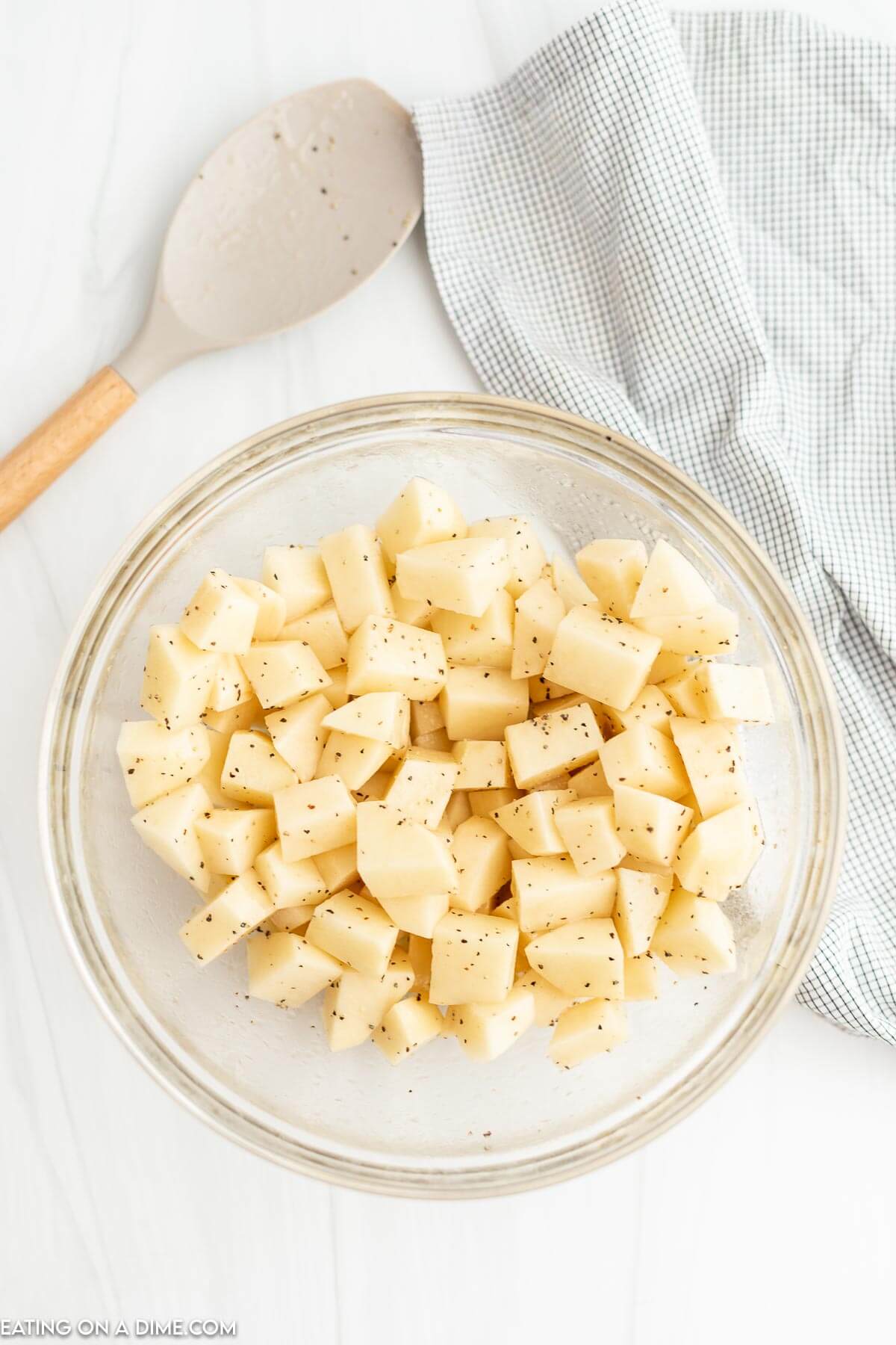 Diced potatoes seasoned in a clear bowl