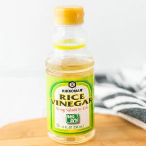 A bottle of rice vinegar on a wooden platter.