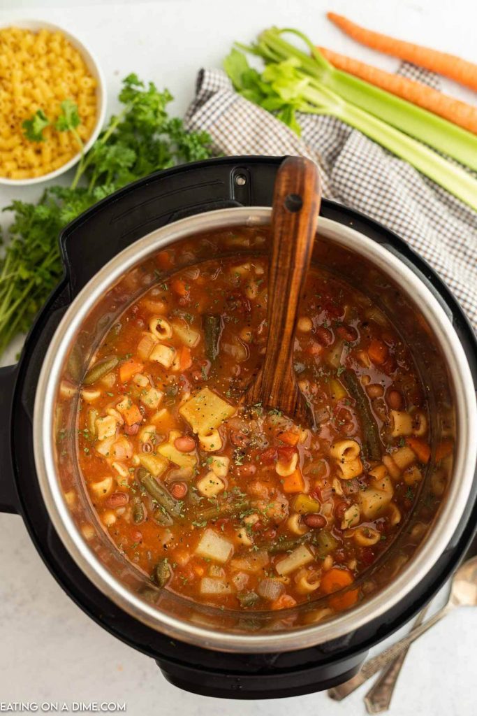 Minestrone soup in the instant pot with a wooden spoon