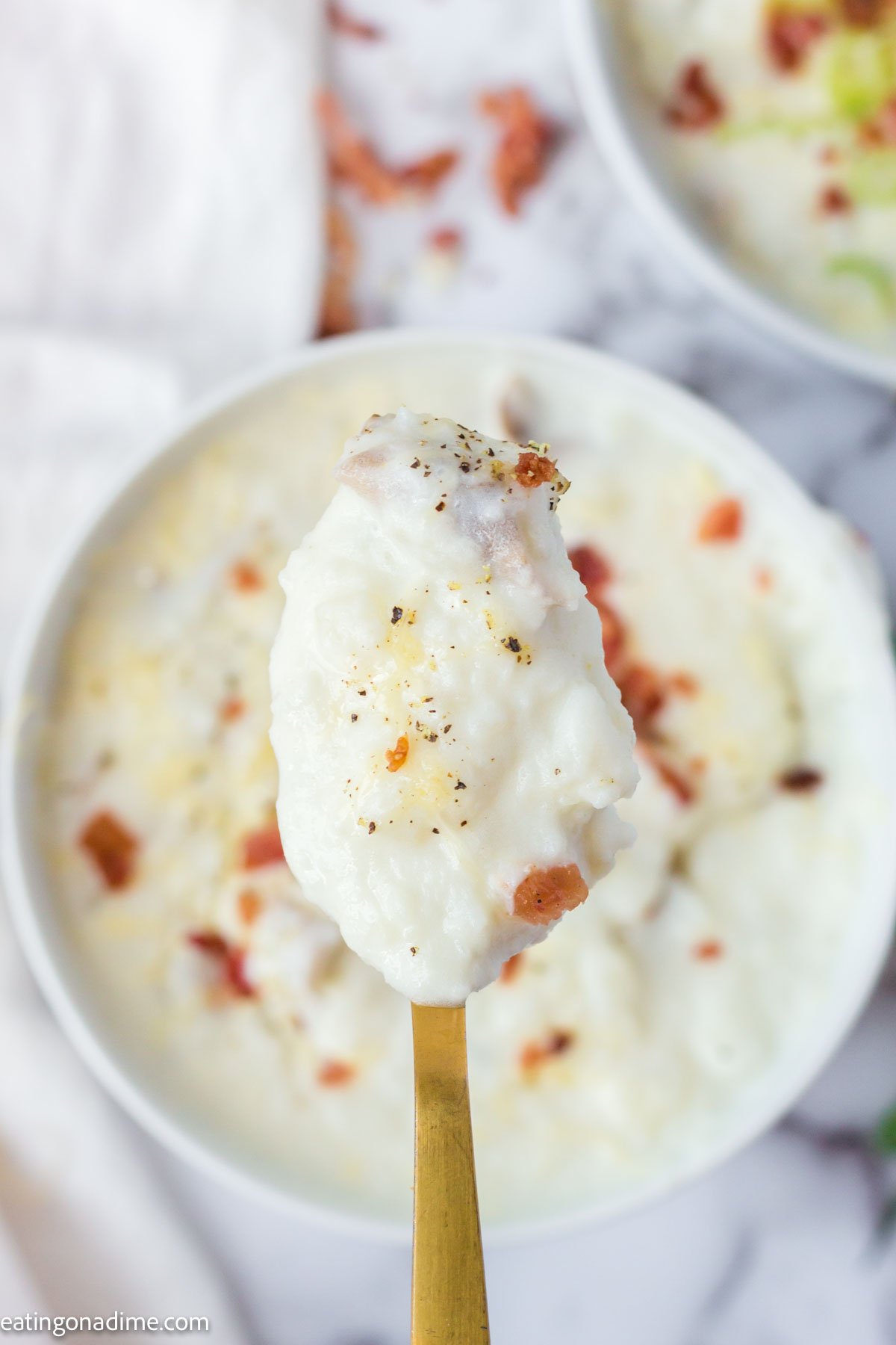 Close up photo of 4 ingredient potato soup on a spoon. 