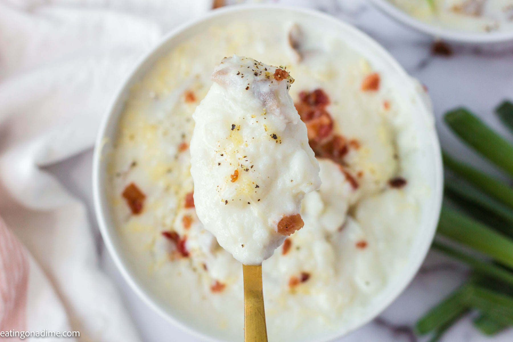 Close up photo of 4 ingredient potato soup on a spoon. 