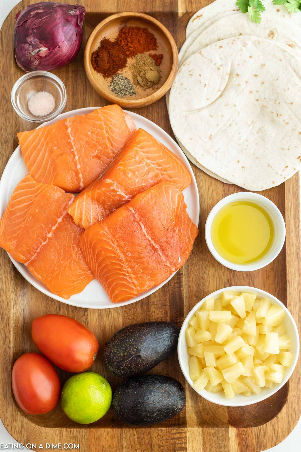 Ingredients for Grilled salmon tacos - Salmon Filets, olive oil, chile powder, paprika, cumin, salt, pepper, lime, pineapple tidbits, tomatoes, onion, avocados, cilantro, tortillas, red cabbage, cotija cheese