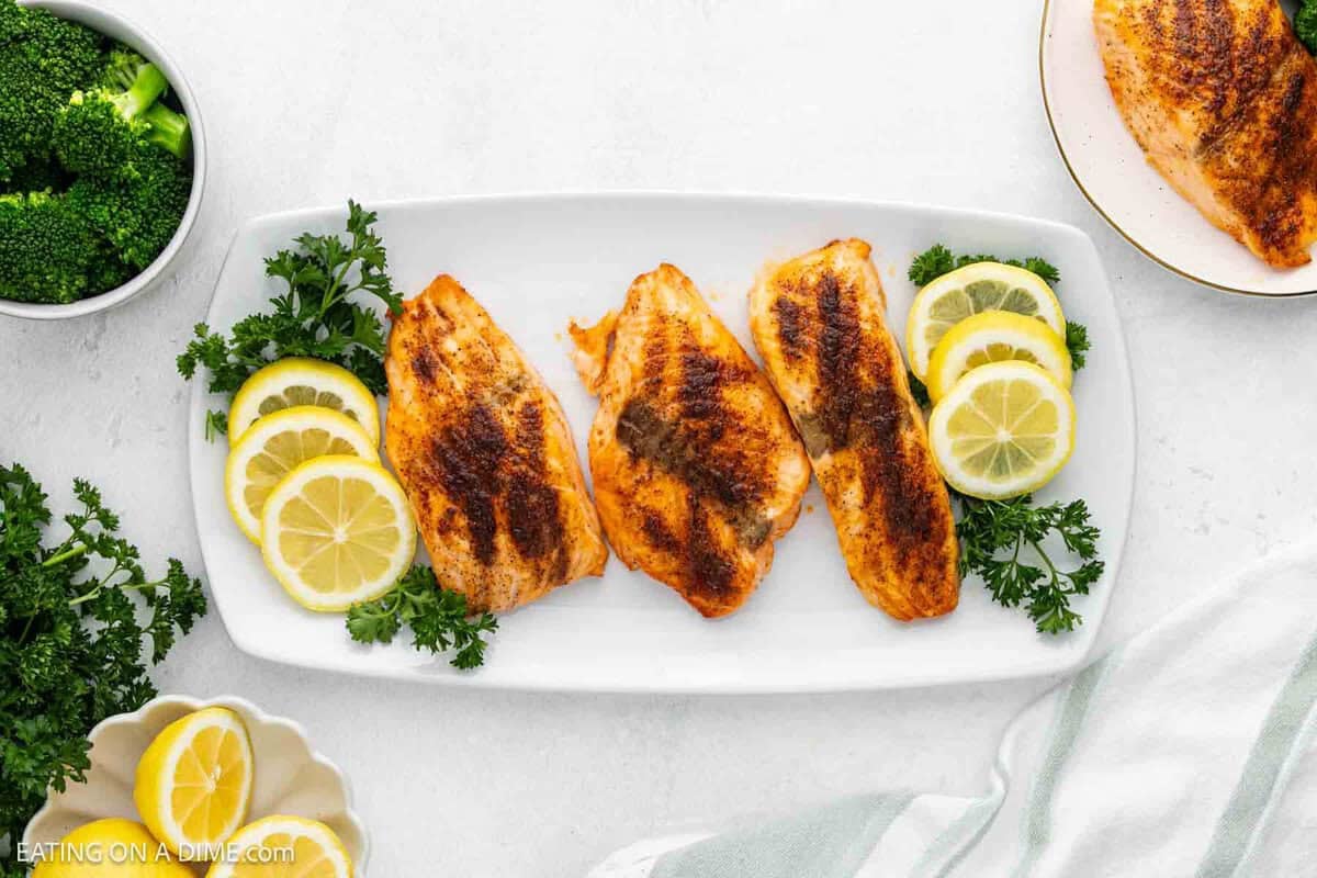 Cooked salmon on a platter with slice lemons