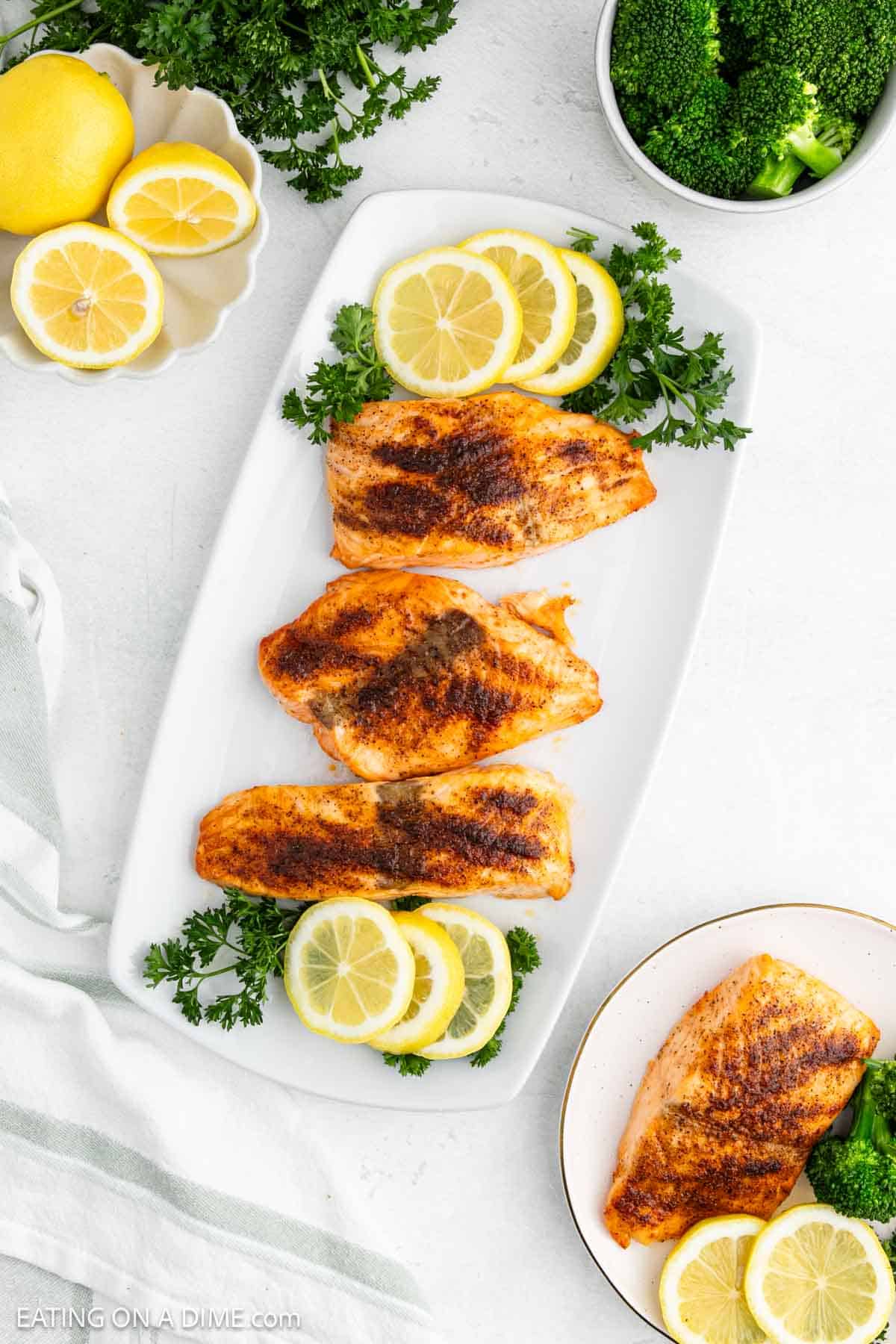 Air Fryer Salmon Filets on a platter with fresh lemon and fresh parsley