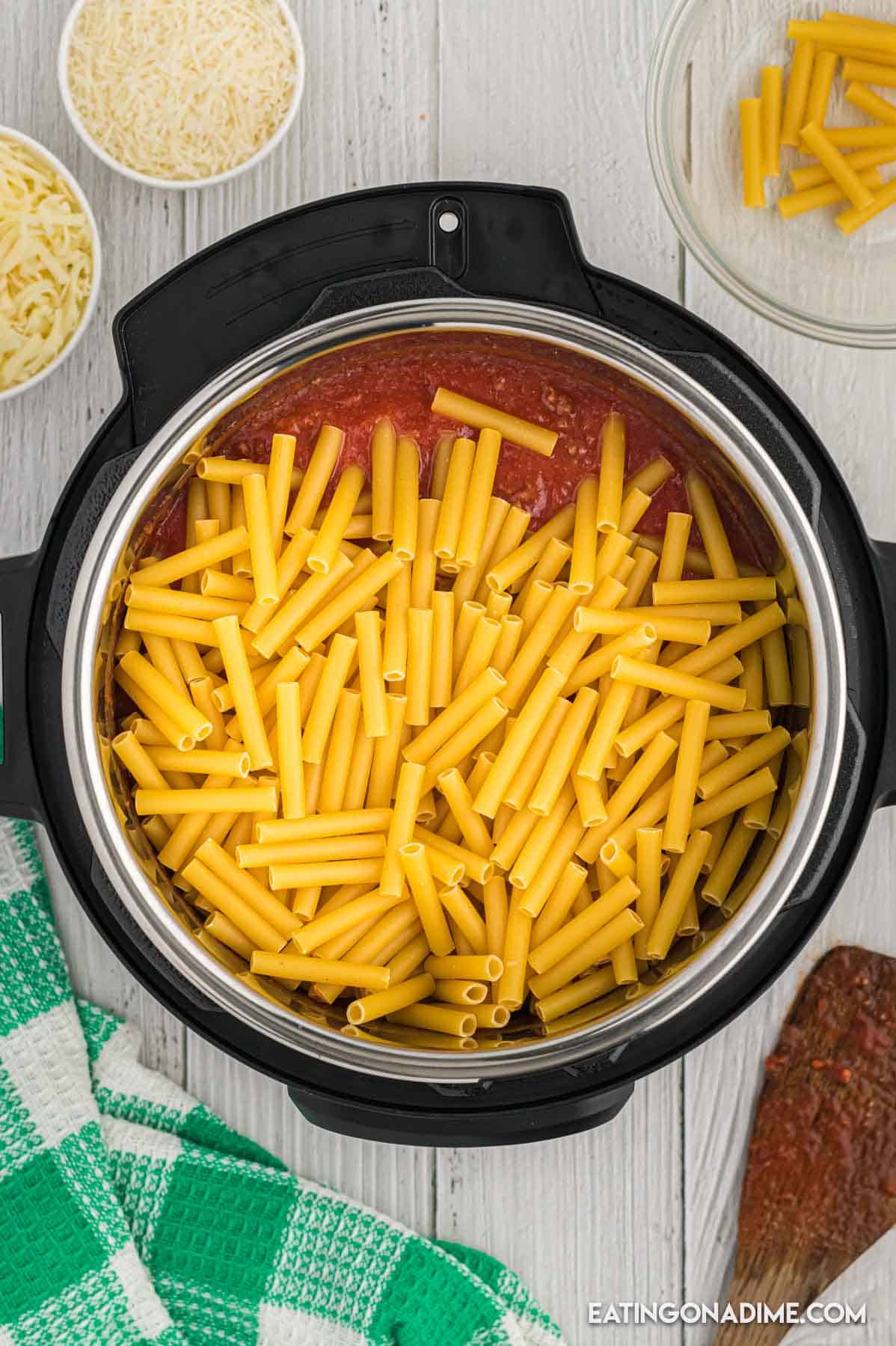 Uncooked pasted added to the instant pot on top of the sauce