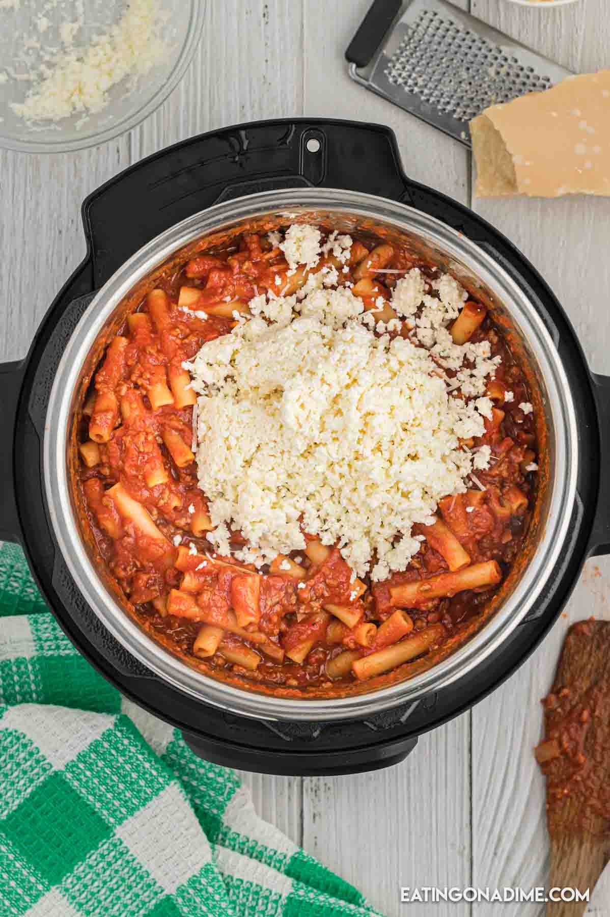 Cooked baked ziti in the instant pot topped with shredded cheese