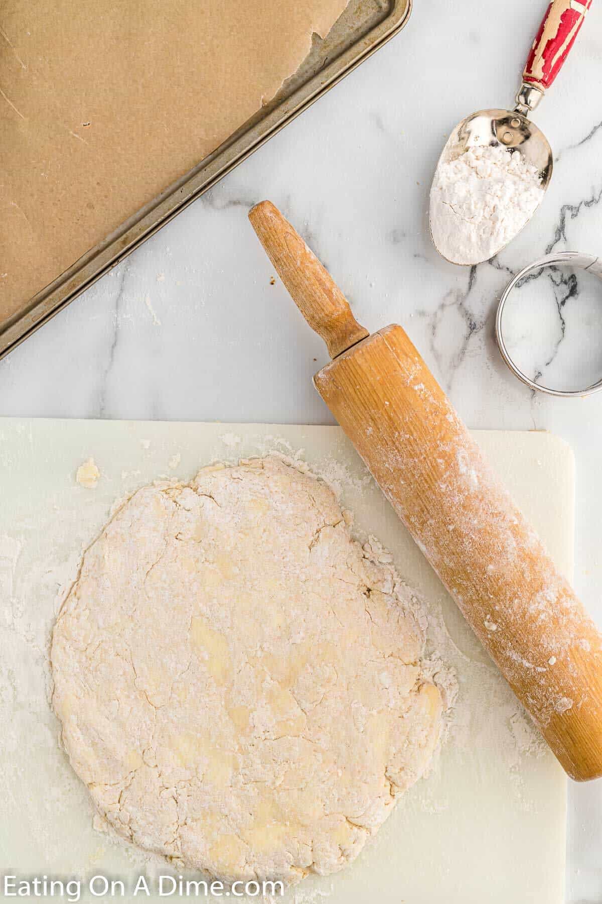 Rolling the dough on a floured surface with a rolling pin