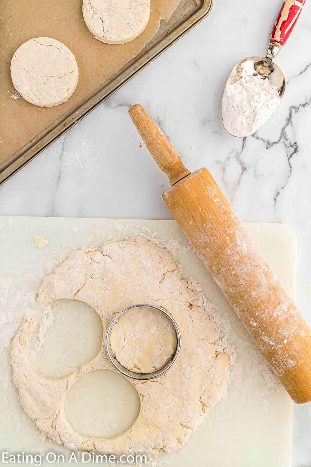 Using a biscuit cutting to cut the dough into round circles