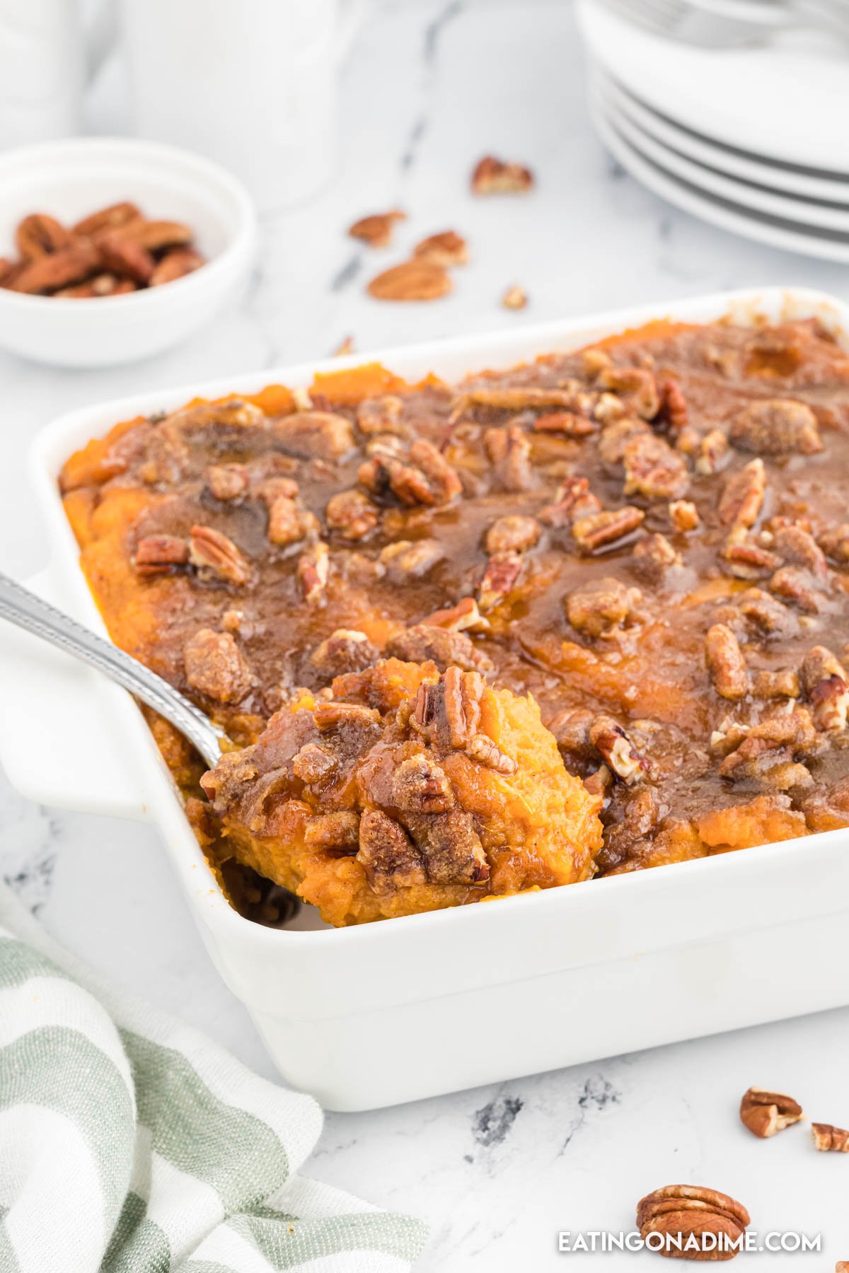 sweet potato casserole in a baking dish with a serving on a spoon