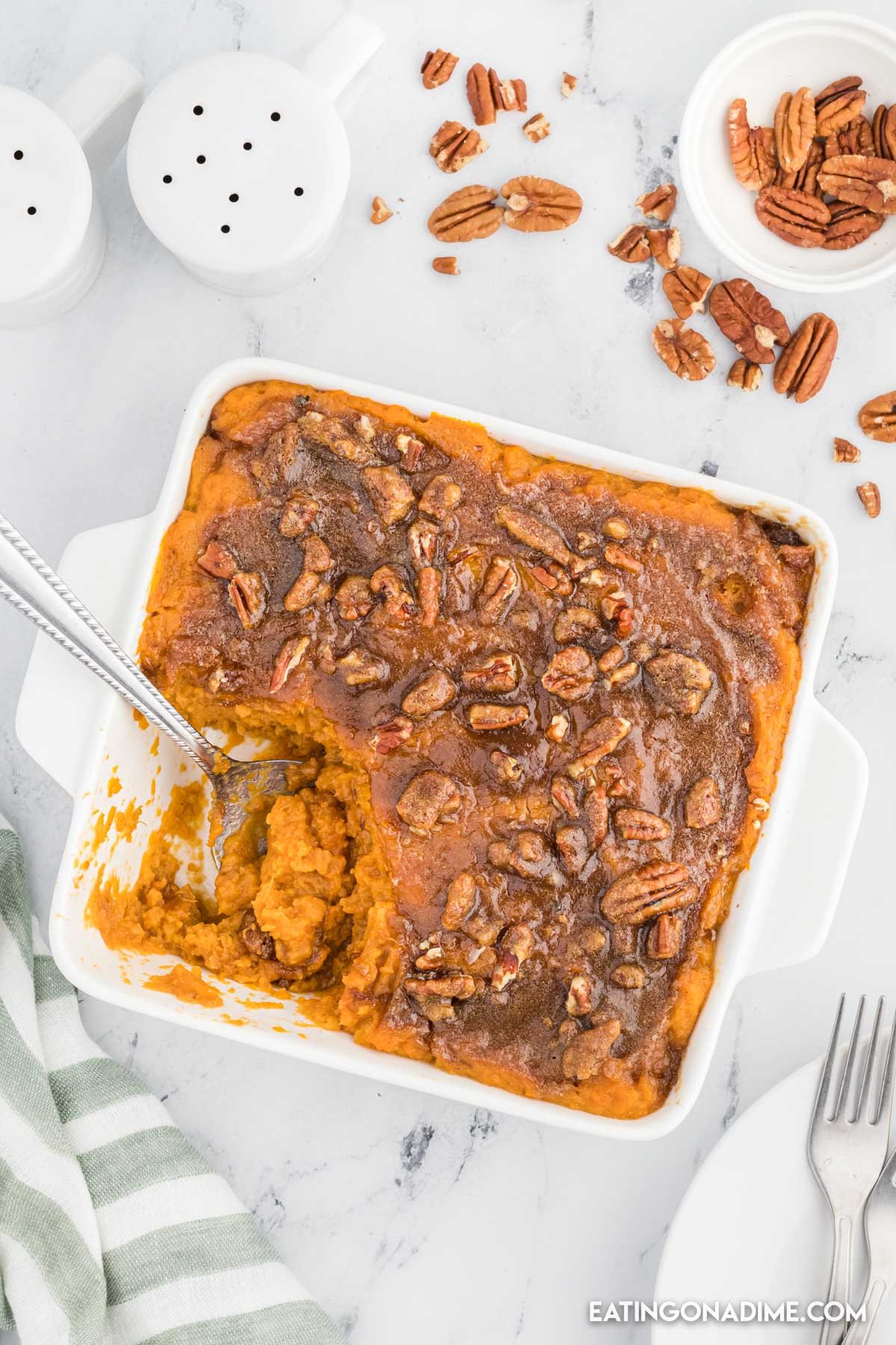 sweet potato casserole in a baking dish with a serving on a spoon