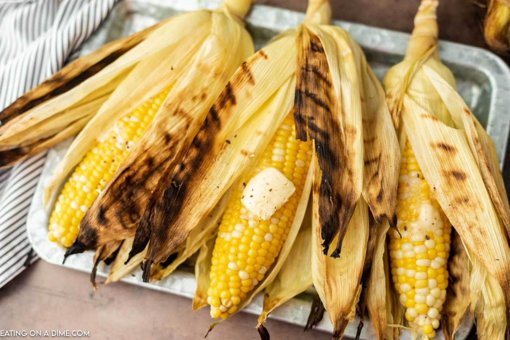 Grilled Corn in the Husk in a tray.