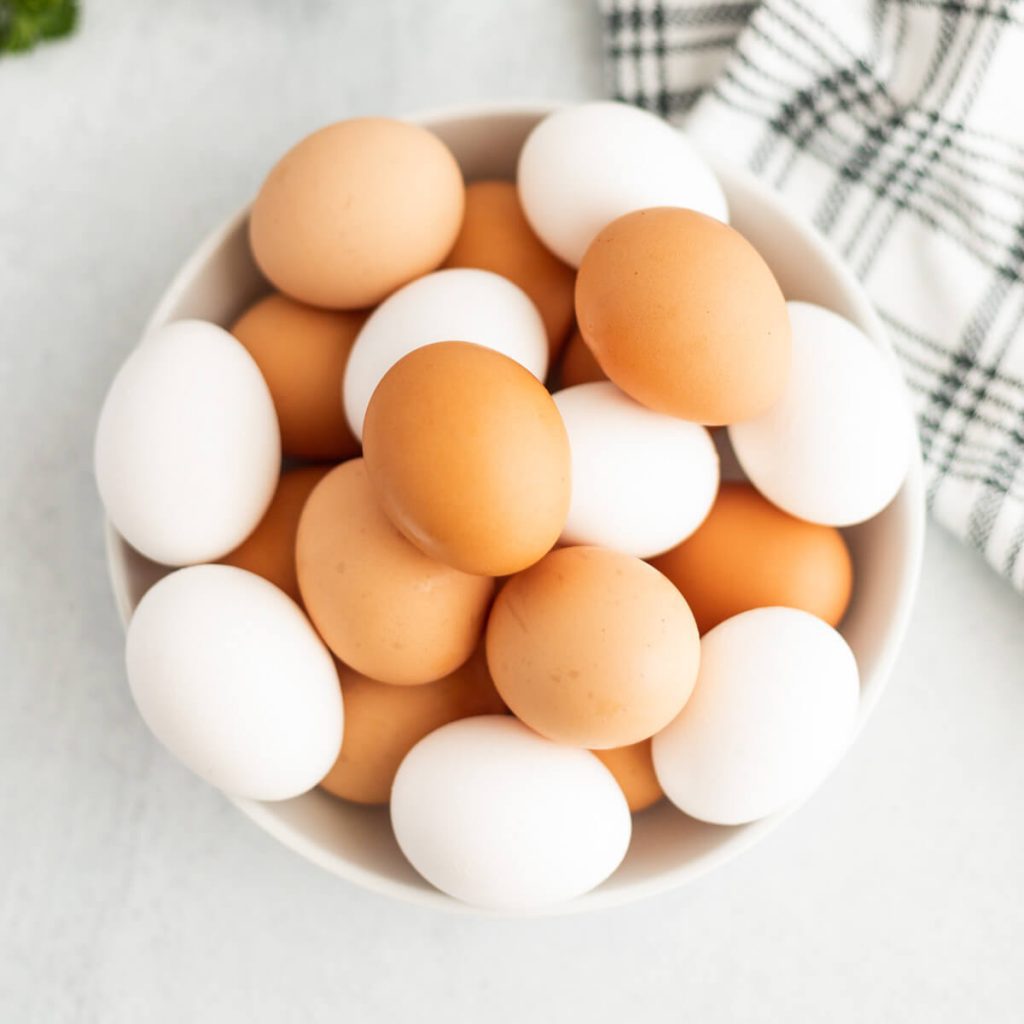Brown and White eggs in a white bowl.