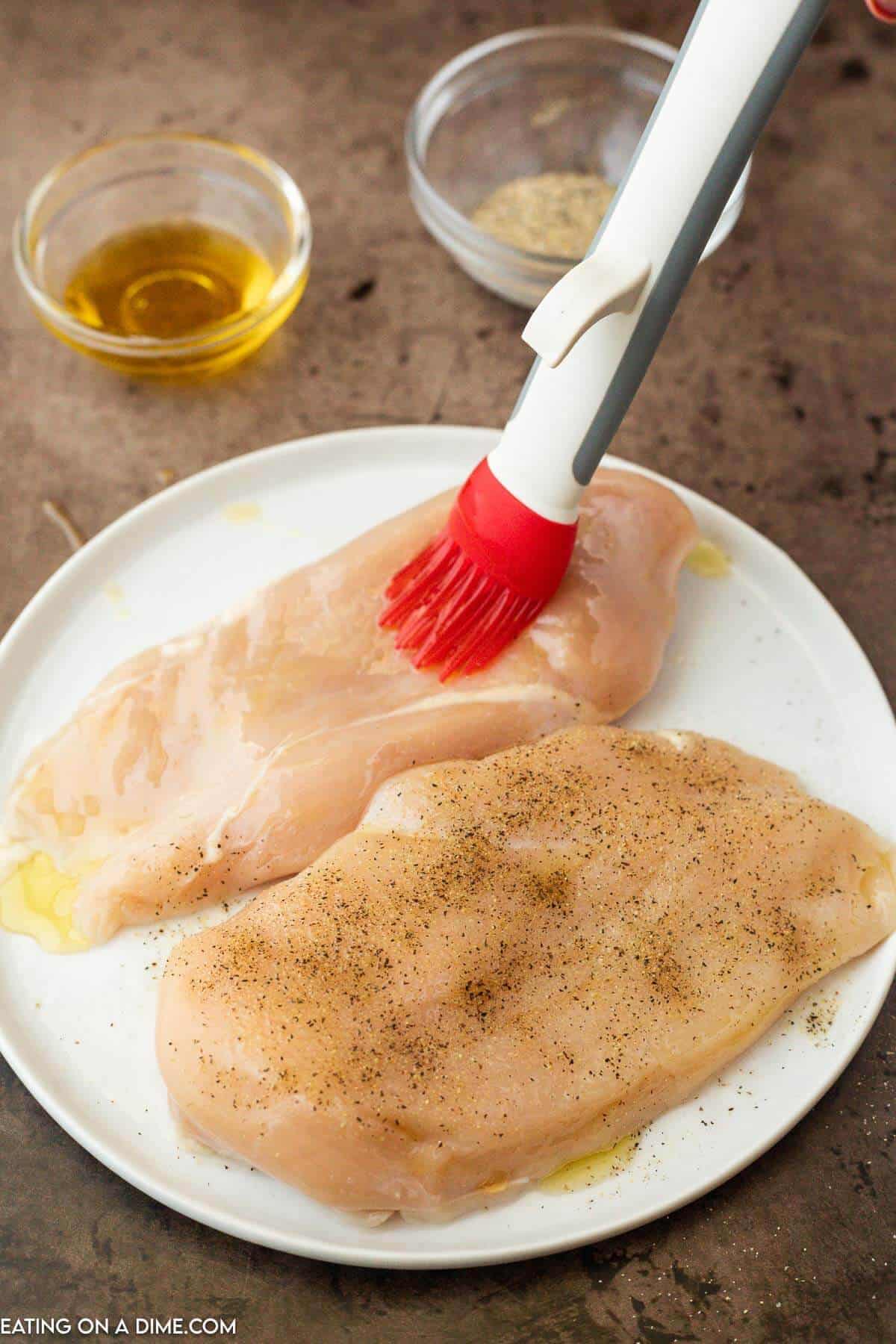 Brushing oil and seasoning on the chicken breast