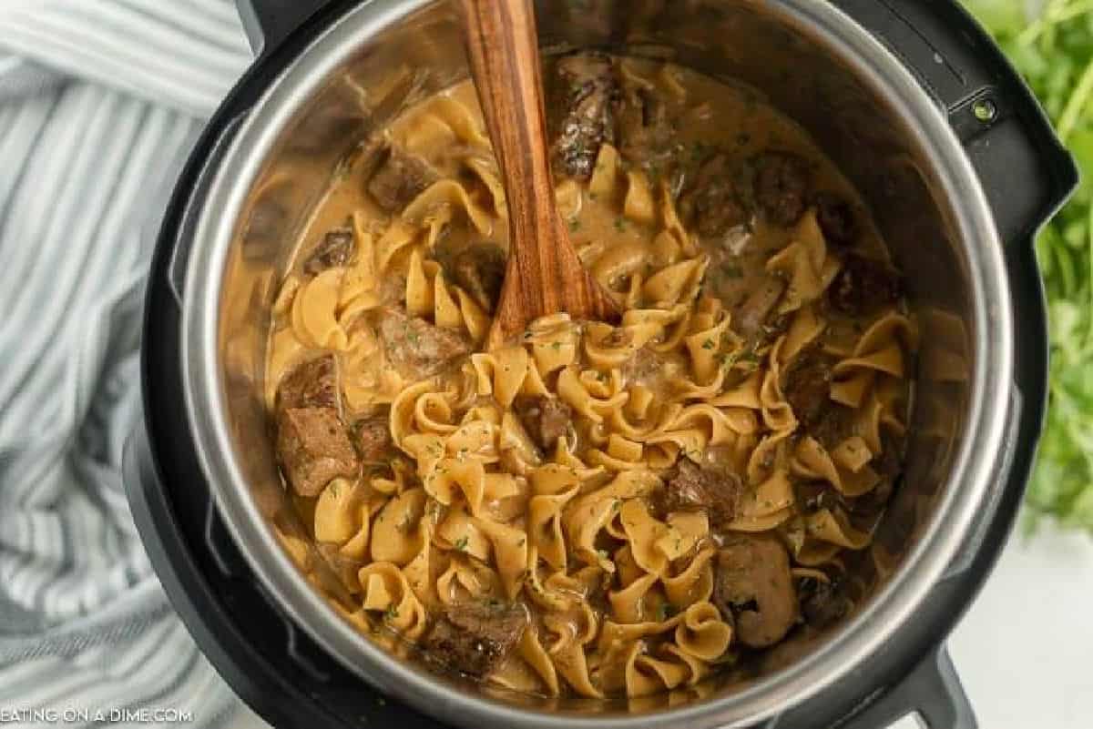 Stroganoff in the pot with a wooden spoon.