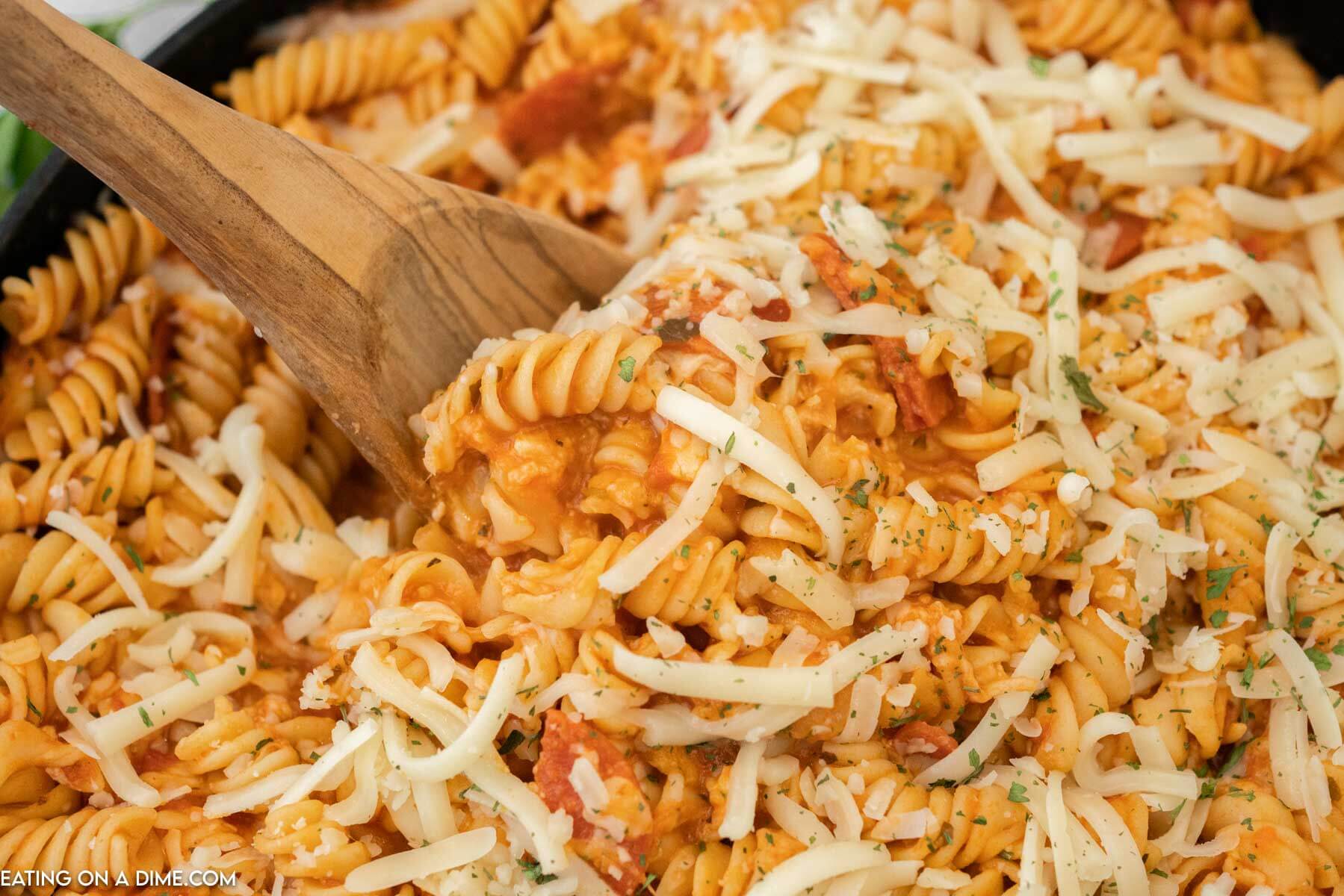 Pepperoni pasta being stirred with a wooden spoon