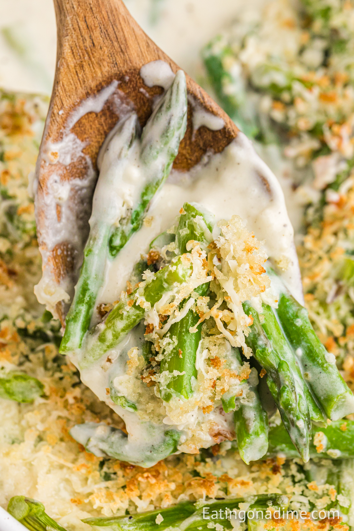 Asparagus casserole on a spoon being served.