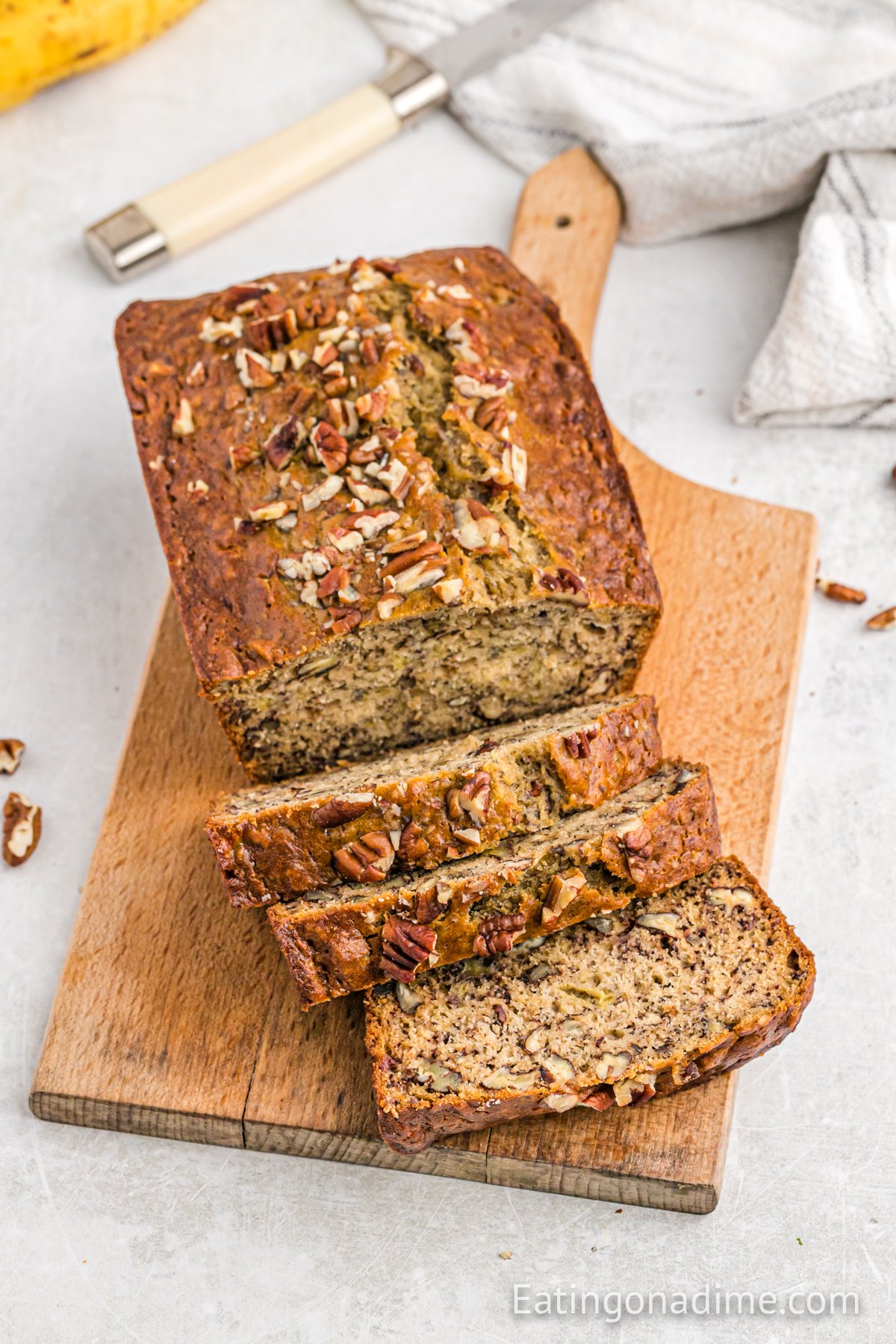 A loaf of banana bread sliced on a cutting board