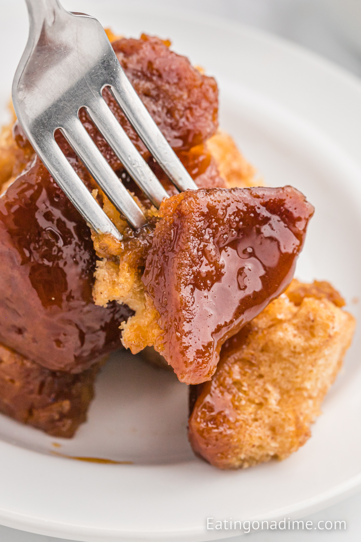 A serving of monkey bread on a white plate with a fork