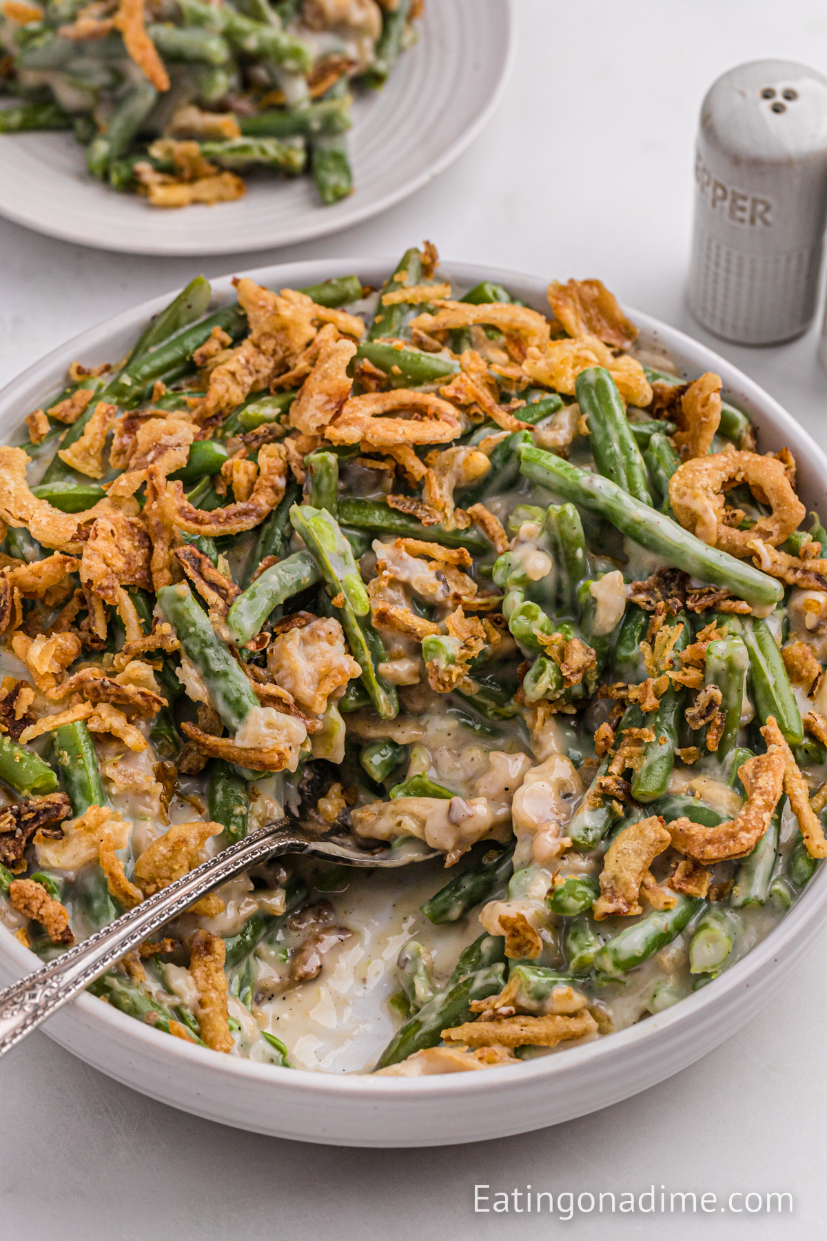 Green Bean Casserole in a white bowl with a spoon