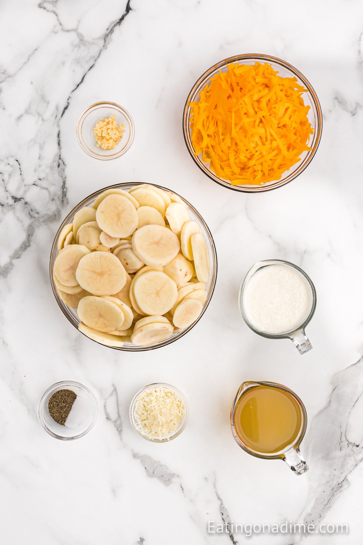 Ingredients needed - potatoes, heavy whipping cream, chicken broth, minced garlic, parmesan cheese, cheddar cheese, salt and pepper
