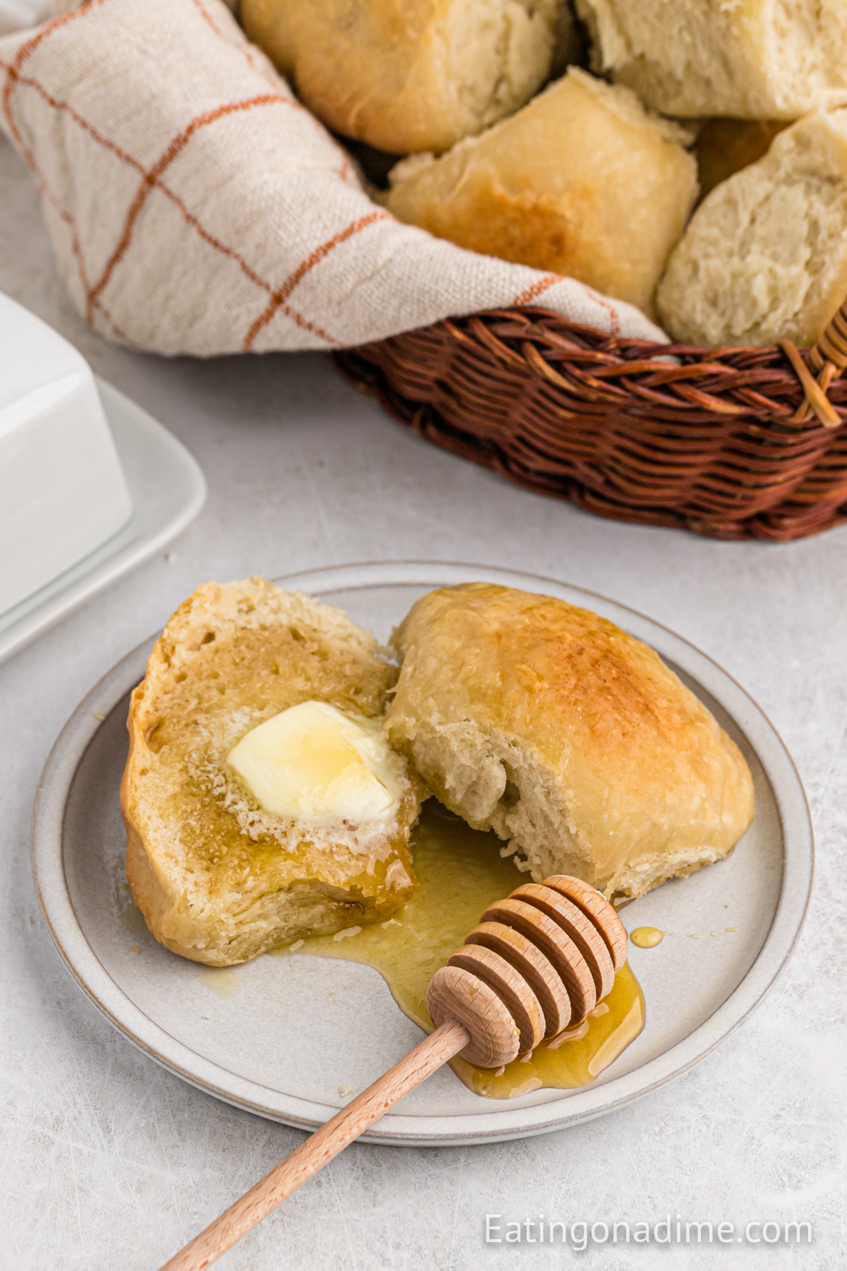 dinner rolls topped with butter and honey on a plate