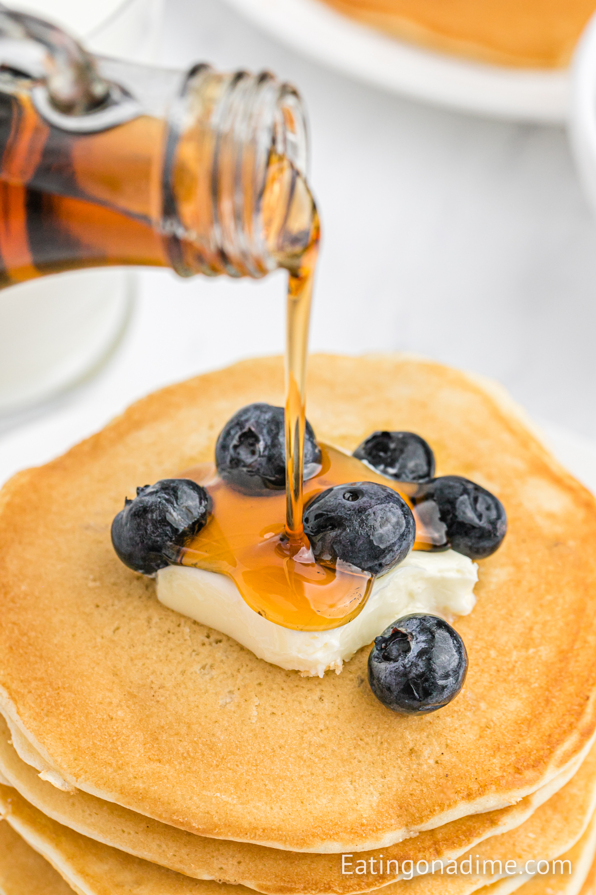 Sweet Cream Pancakes with butter, blueberries and syrup on the top