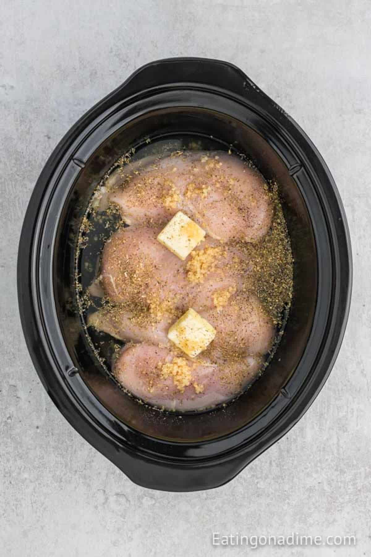 Chicken breasts in the crock pot with butter, wine, and seasoning.