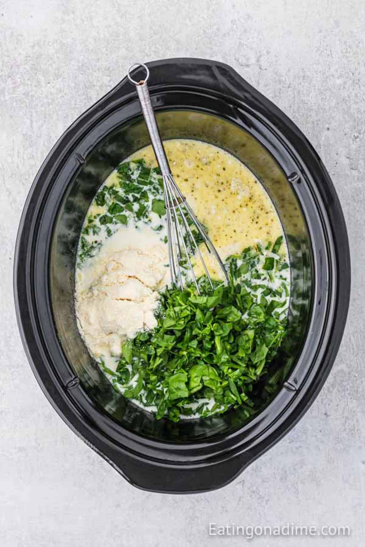 Shredded spinach, parmesan cheese, heavy cream is added to the slow cooker.