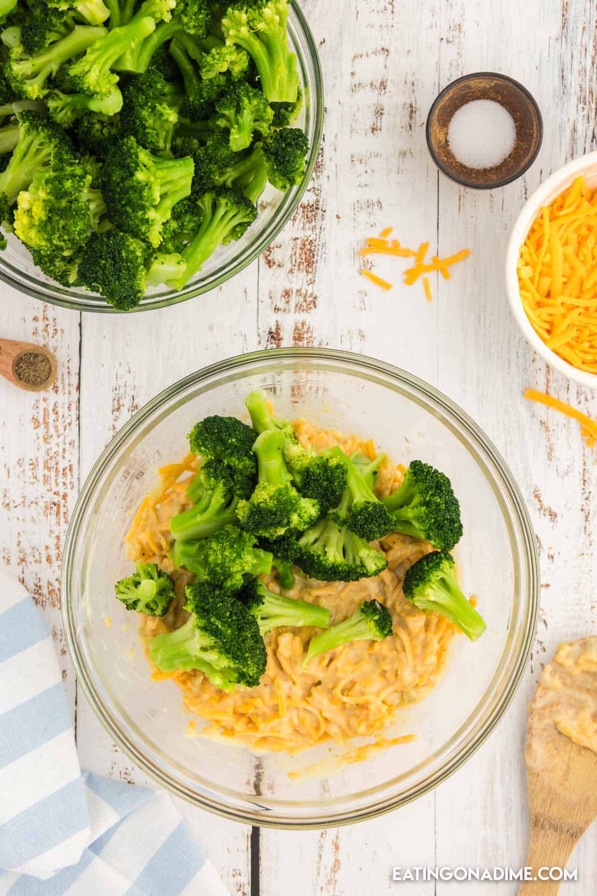 Adding broccoli florets to the cheese mixture in a bowl