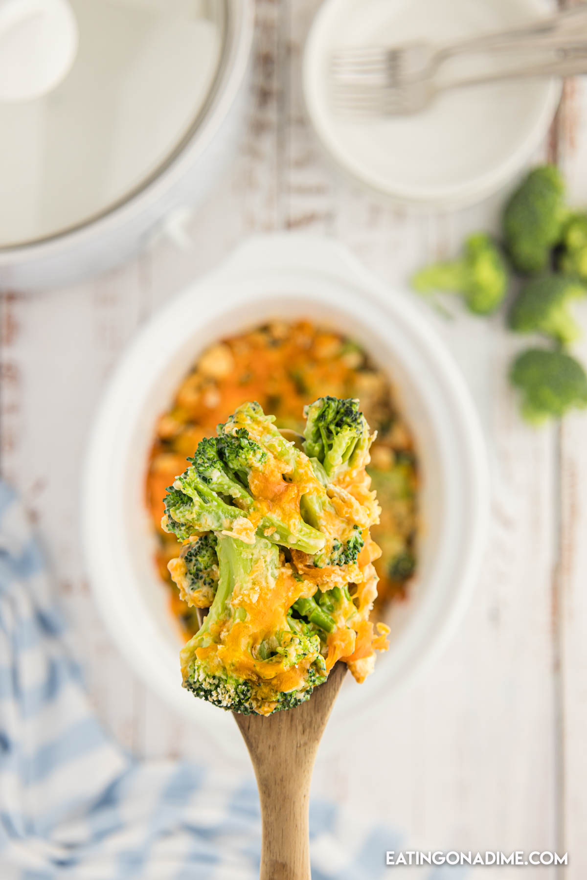 A serving of broccoli cheese casserole on a wooden spoon. 