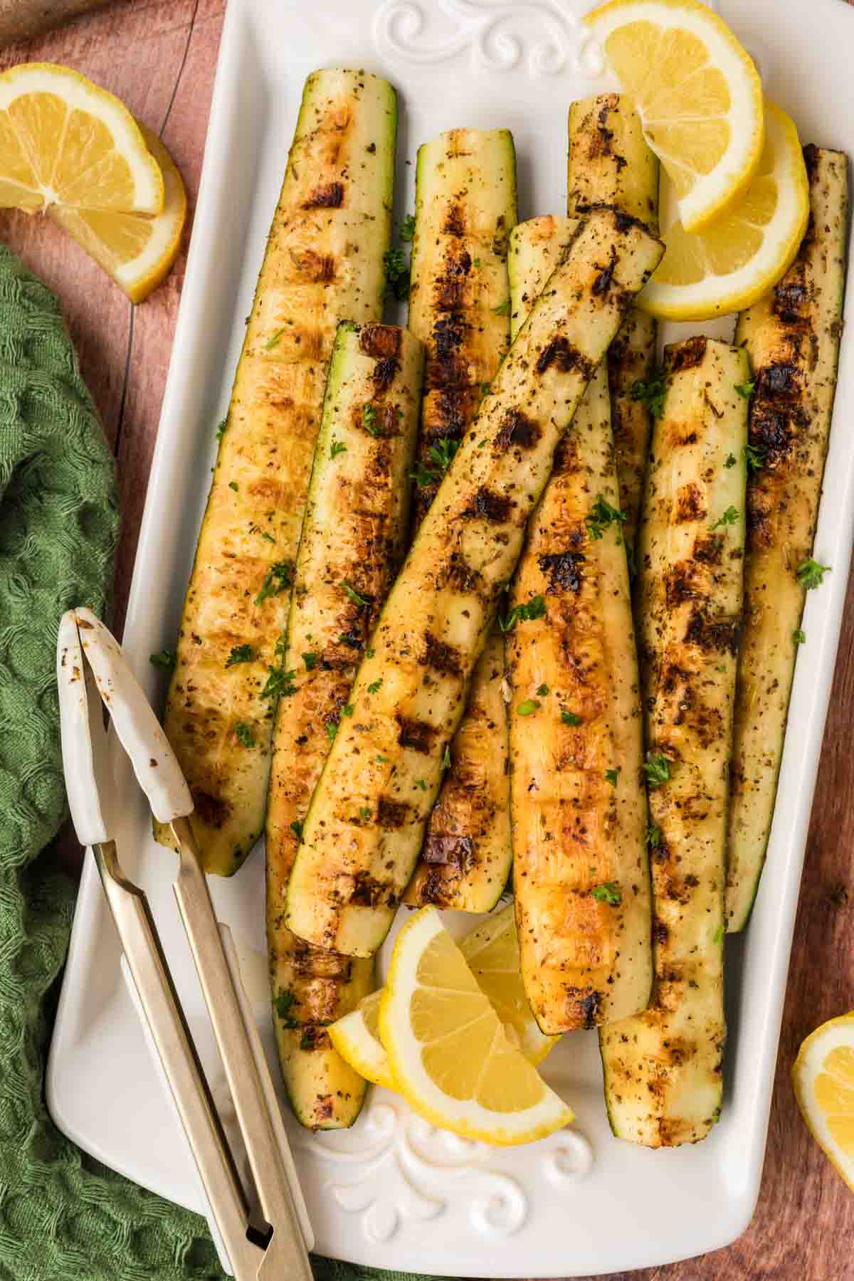 Grilled Zucchini Spears on a platter with fresh slices of lemon
