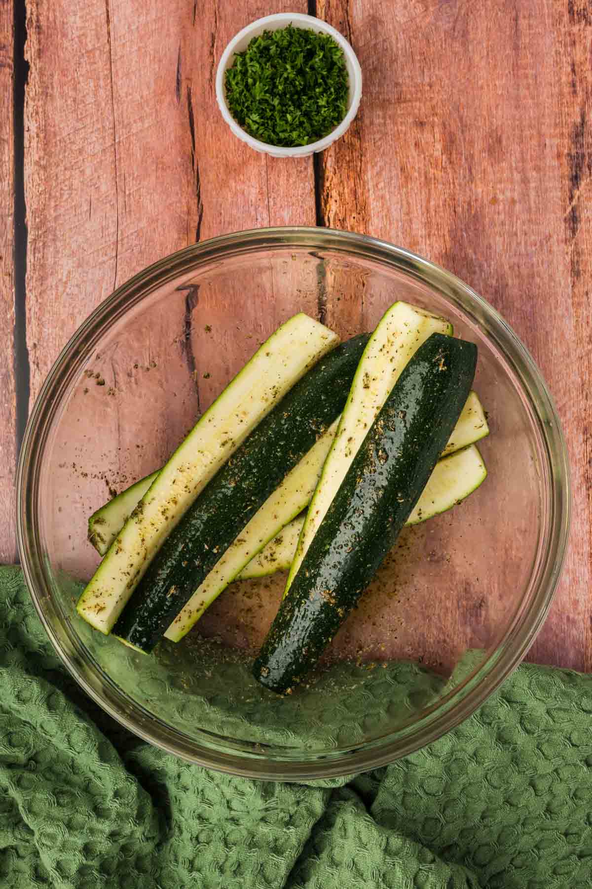 Tossing the zucchini spears with the seasoning in a bowl